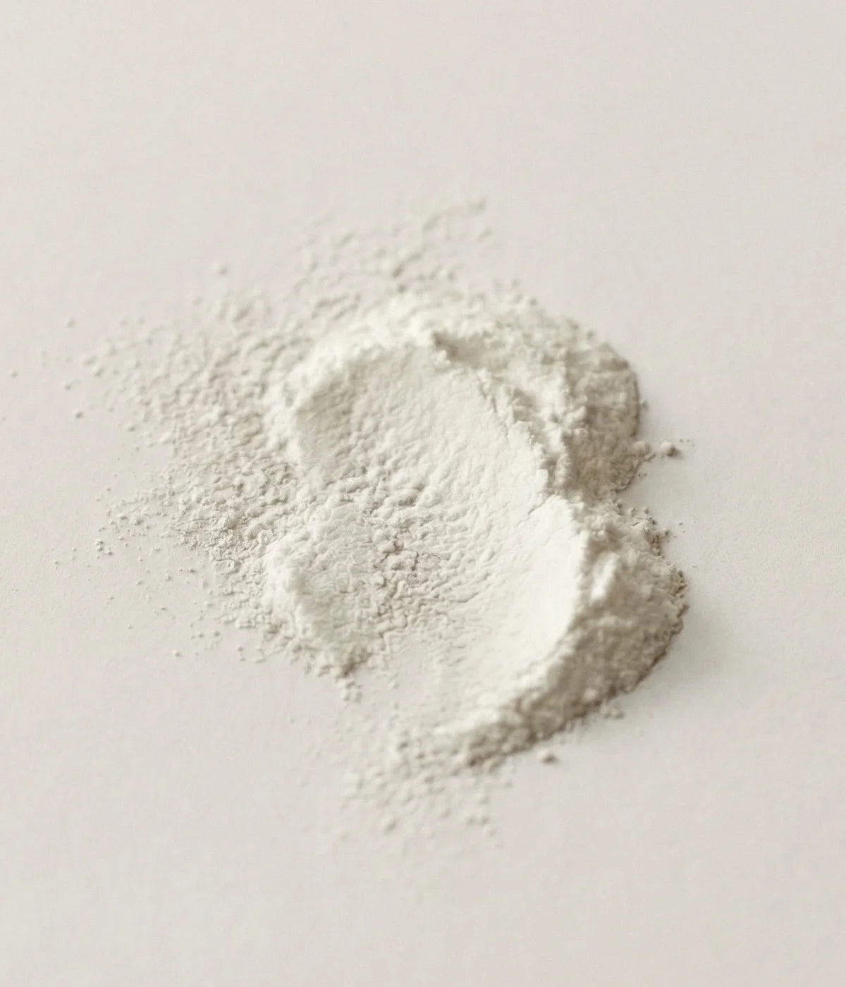 Pile of hydroxyapatite on a light gray background.